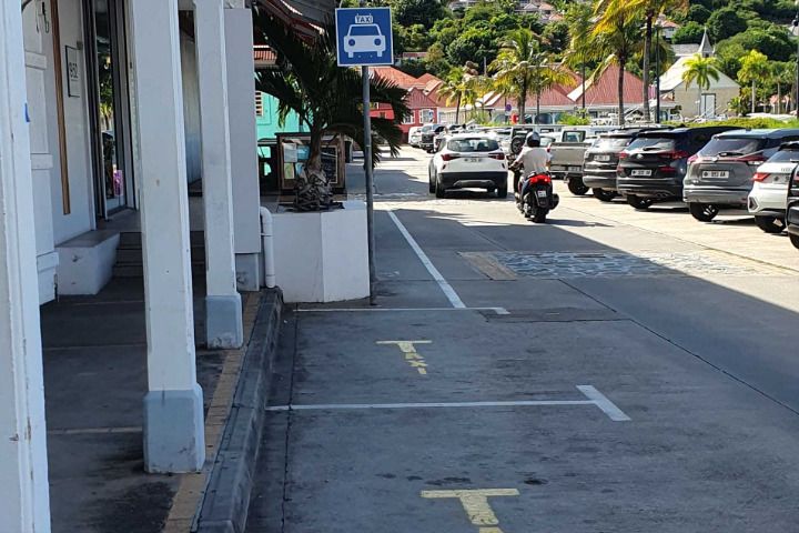 Blue taxi sign and yellow taxi bay markings painted on a street in Gustavia, St Barts