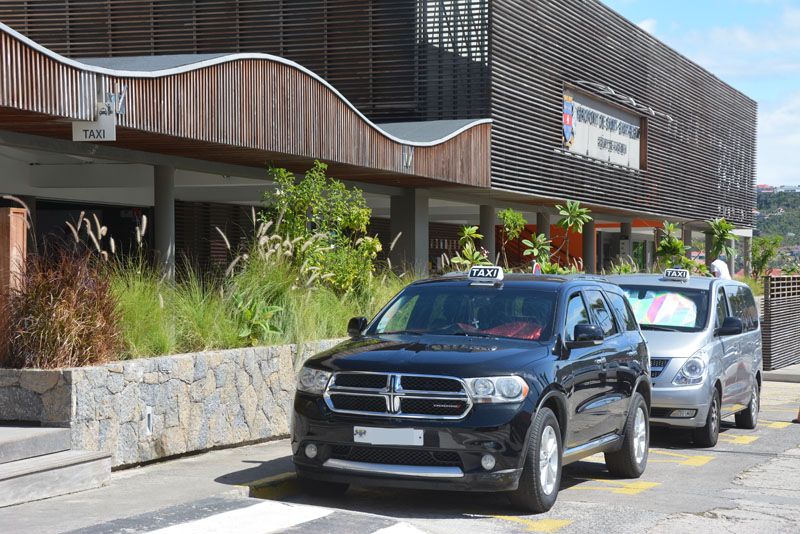 Two taxis waiting at the taxi stand outside the Gustaf III Airport terminal in St Barts